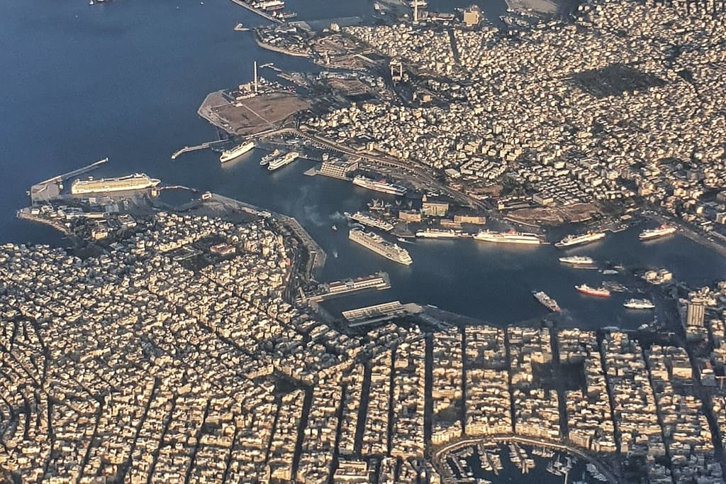Piraeus seen from the air, with ferries berthed along the length of the waterfront.