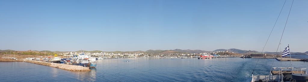 Wide view across Lavrio harbour towards the low town and hills behind it.