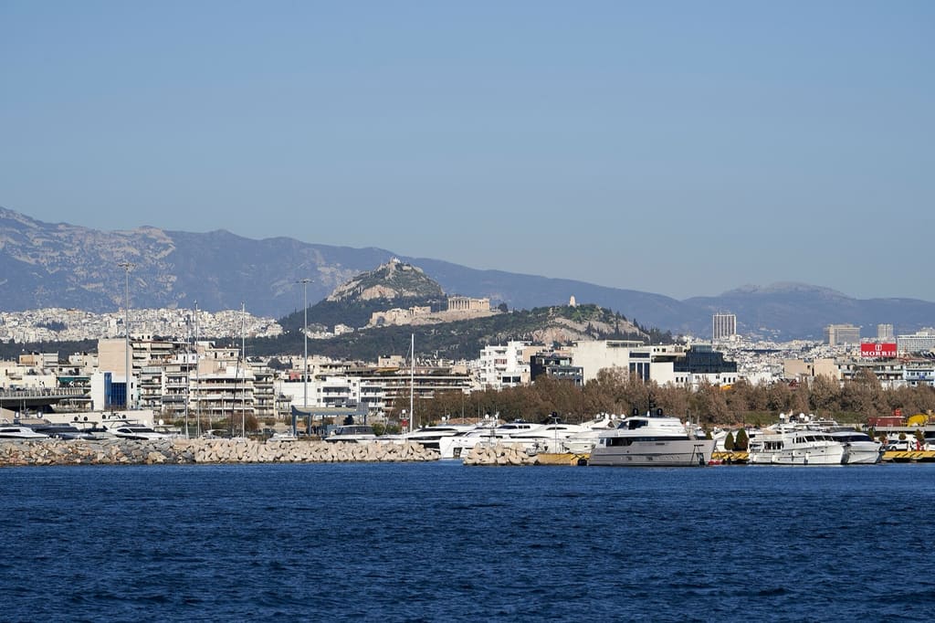 Yachts moored at Mikrolimano marina in Piraeus, with the Acropolis on the skyline behind.